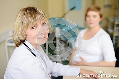 Gynecologist doctor accepts of a pregnant woman. Medical insurance childbearing. Family doctor for gestation. Maternity leve Stock Photo