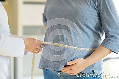 Gynecologist doctor measures with centimeter tape of a pregnant woman. Medical insurance childbearing. Family doctor for gestation Stock Photo