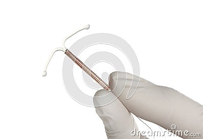 Gynecologist holding copper intrauterine contraceptive device on white background, closeup Stock Photo