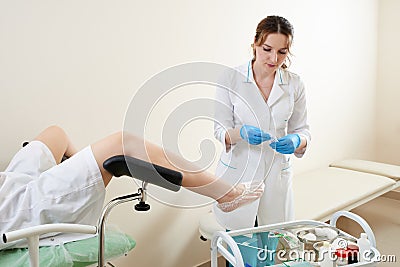 Gynaecologist examining a patient sitting on gynecological chair Stock Photo