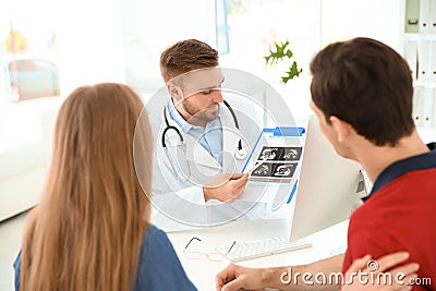 Gynecology consultation. Doctor showing ultrasound of baby Stock Photo
