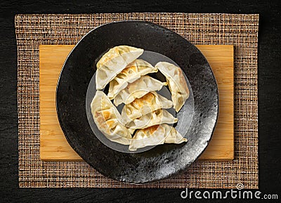 Gyoza Chinese Dumplings Top View, Vegetable Jiaozi, Chicken Momo Pile, Asian Gyoza Portion on Black Stock Photo