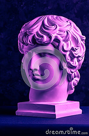 Gypsum copy of ancient famous statue Antinous head on dark textured background. Plaster antique sculpture young man face Stock Photo