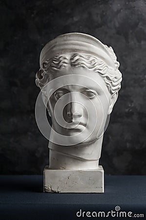 Gypsum copy of ancient statue Diana head on a dark textured background. Plaster sculpture woman face. Stock Photo
