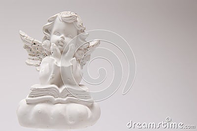 Gypsum white angel on a white background reading a book and thinking Stock Photo