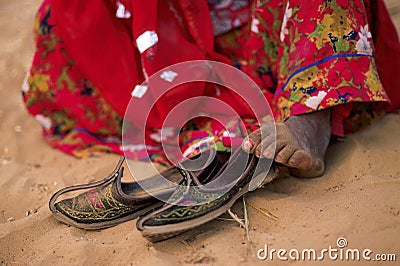 A gypsy Indian woman is wearing a red sari while she is sitting Stock Photo