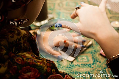 Gypsy psychic looking for a man in a photo using a pendulum. Love spell on photos Stock Photo