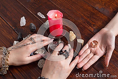 A Gypsy woman performs a love spell. A clairvoyant palmist reads by hand with a candle. A fortune teller predicts the fate of love Stock Photo