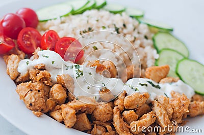 Gyros chicken with rice, tzatziki dressing and vegetables Stock Photo