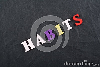 HABITS word on black board background composed from colorful abc alphabet block wooden letters, copy space for ad text. Learning Stock Photo