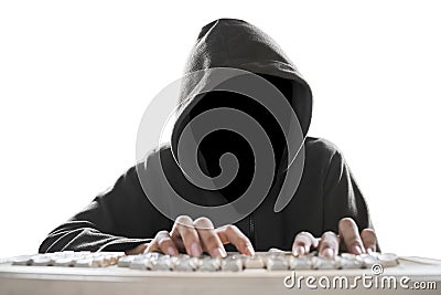 Hacker with dark face typing on computer keyboard Stock Photo