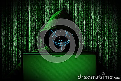 Hacker with glowing mask behind notebook laptop in front of green source binary code background internet cyber hack attack concept Stock Photo