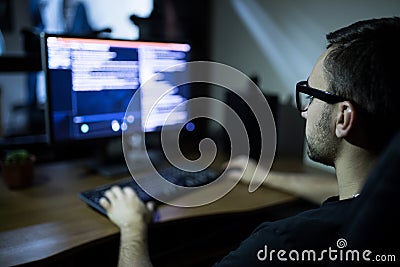 hacker in headset and eyeglasses with keyboard hacking computer system Stock Photo