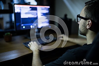 Hacker in headset and eyeglasses with keyboard hacking computer system Stock Photo