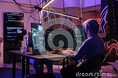 Hacker in hood using spyware Stock Photo