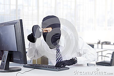 Hacker looking for information in office Stock Photo