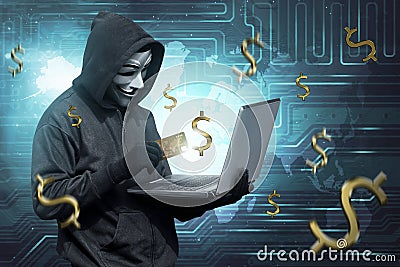 Hacker man with mask holding credit card with laptop on his hand Editorial Stock Photo