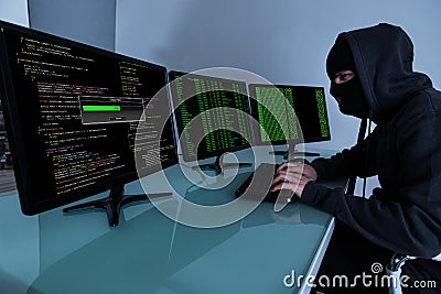 Hacker Stealing Data On Multiple Computers Stock Photo