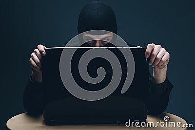 Hacker stealing data off a laptop computer Stock Photo