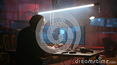 Hacker using computer to run malicious code in foggy dark basement Stock Photo