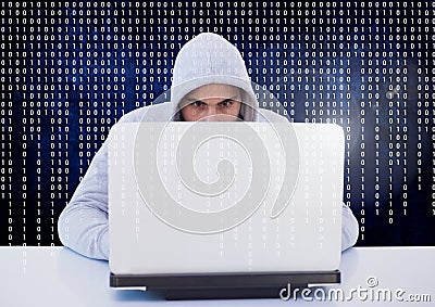 Hacker using a laptop in front of digital screen Stock Photo