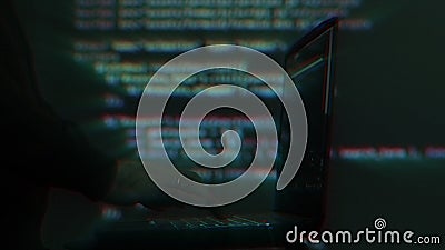 Hacker writing code cracking computer. Programming code in the background. Hacker attack, cybercrime, virus software Stock Photo