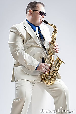 Hadnsome Male Saxophone Player Playing in Studio Stock Photo