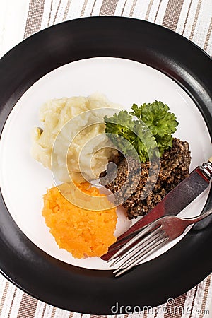 Haggis with mashed potato, turnip and parsley on a plate Stock Photo