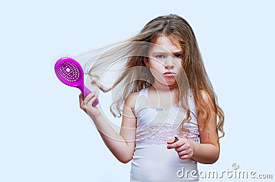 Hair care concept with portrait of girl brushing her unruly, tangled long hair Stock Photo