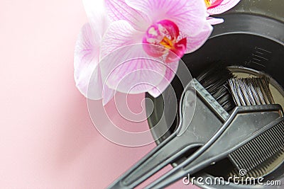 Brush for bleach hair and plastic black bowl. Hairdressing tools with copy space on pink background. Top view. Flat lay Stock Photo