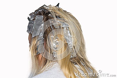 Hair highlights wrapped in aluminum foil. Stock Photo