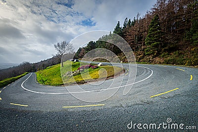 Hair pin bend on mountain country road on a bright cloudy day in Ireland. Stock Photo