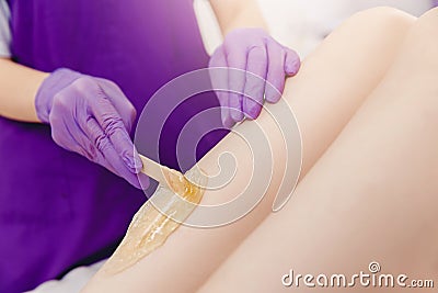 Hair removal concept. Application of sugar paste for shugaring depilation on skin of girl legs Stock Photo
