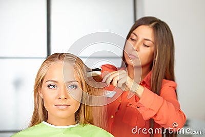 Hair salon. Womens haircut. Use of straightener. Stock Photo