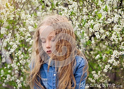 Hair in the wind close the girl`s face in the cherry orchard. Stock Photo