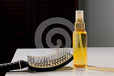 Hairbrush with hairs and hair loss remedy on table, cure of loss hair alternative medicine concept Stock Photo