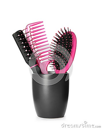 Hairbrushes and comb in holder on white Stock Photo