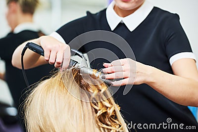 Hairdo in beauty salon. hairdresser making coiffure with curl to wonam Stock Photo