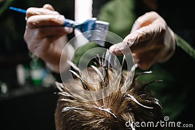 Hairdresser with a brush to apply hair dye. Coloring in the barber shop Stock Photo