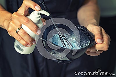 Hairdresser calorist mixes ingredients for hair coloring Stock Photo