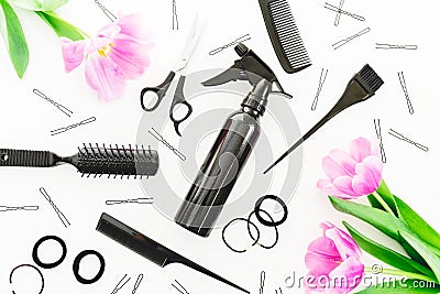 Hairdresser concept with spray, scissors, combs, barrette and tulips flowers on white background. Beauty concept. Flat lay, top vi Stock Photo