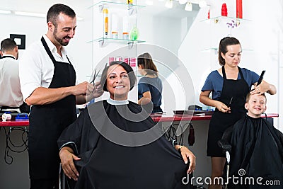 Hairdresser cutting hair of female client Stock Photo