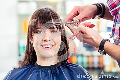 Hairdresser cutting woman bangs hair in shop Stock Photo