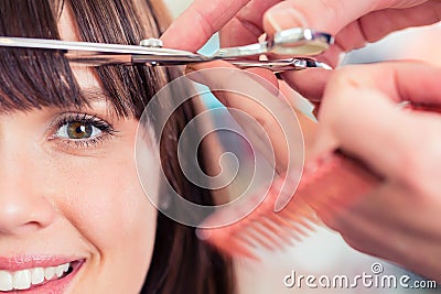 Hairdresser cutting woman bangs hair Stock Photo