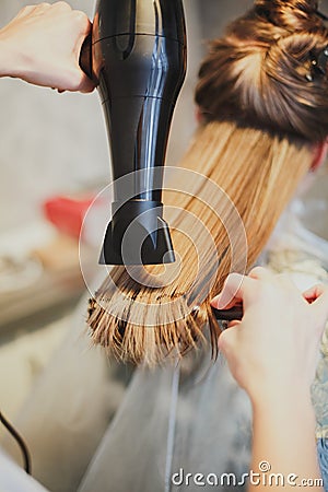 Hairdresser dries hair the girl blonde Stock Photo