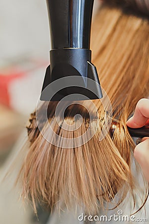 Hairdresser dries hair the girl blonde Stock Photo