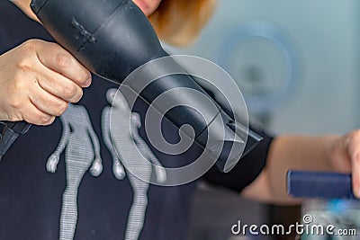 A hairdresser dries women`s hair with a hair dryer in a spa salon Stock Photo