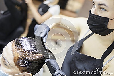 Hairdresser dyes woman hair Stock Photo