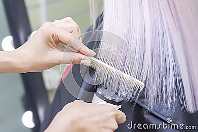 Hairdresser with a hair machine. cutting off split ends of hair with a clipper. close up. blonde hair Stock Photo