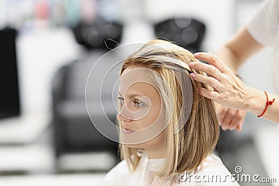 Hairdresser making hair styling to woman client in beauty salon Stock Photo